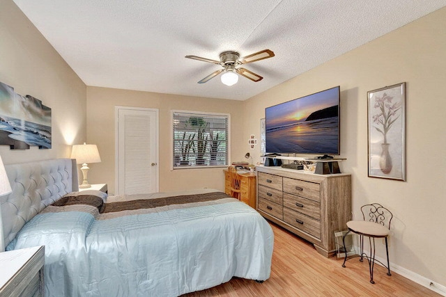 bedroom featuring a textured ceiling, light hardwood / wood-style floors, and ceiling fan