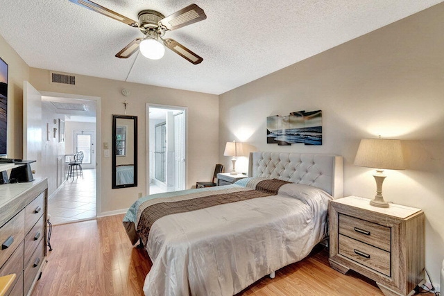 bedroom featuring ceiling fan, a textured ceiling, and light hardwood / wood-style flooring