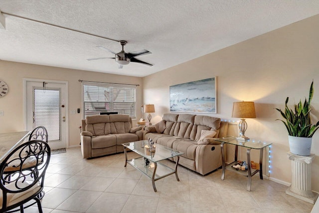 tiled living room with a textured ceiling and ceiling fan