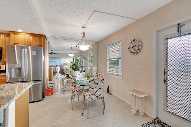 dining space featuring a textured ceiling and light tile patterned floors