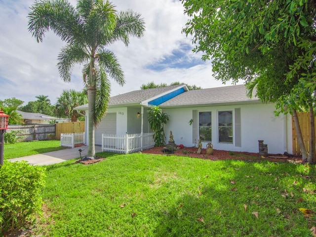 back of property with a garage and a lawn