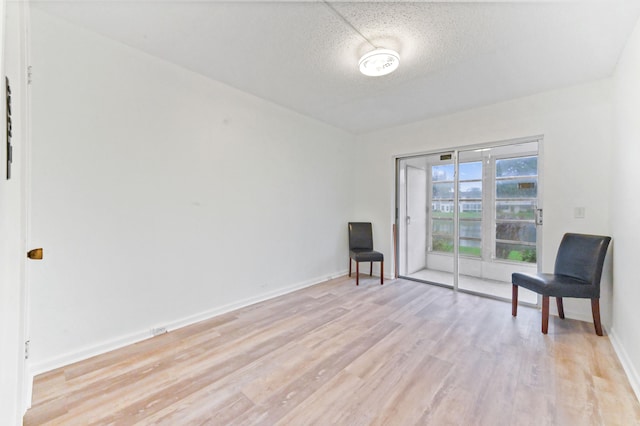 sitting room featuring light hardwood / wood-style floors and a textured ceiling