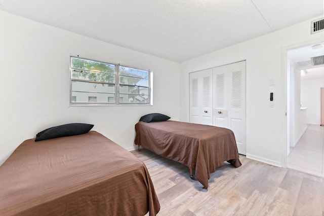 bedroom featuring light wood-type flooring and a closet