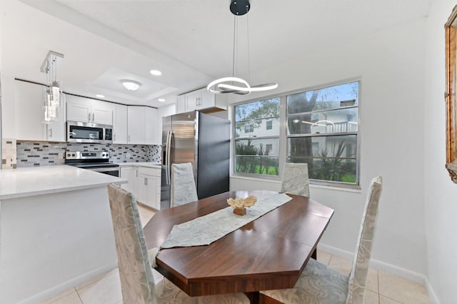 dining area with light tile patterned floors and a raised ceiling