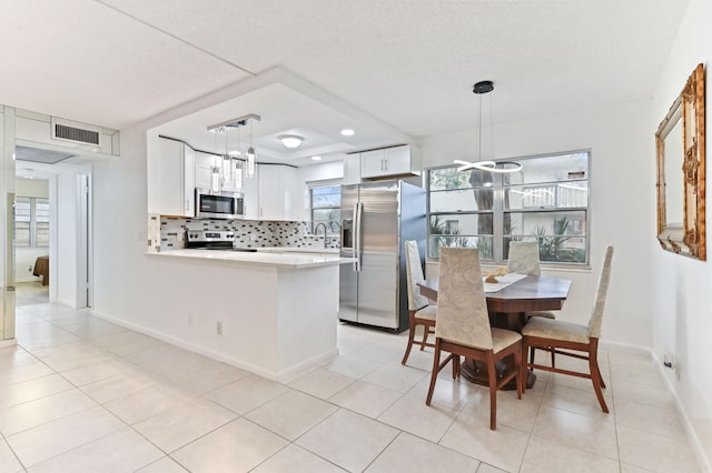 tiled dining room featuring a healthy amount of sunlight and a textured ceiling