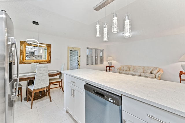 kitchen with stainless steel appliances, white cabinetry, decorative light fixtures, light tile patterned floors, and light stone countertops