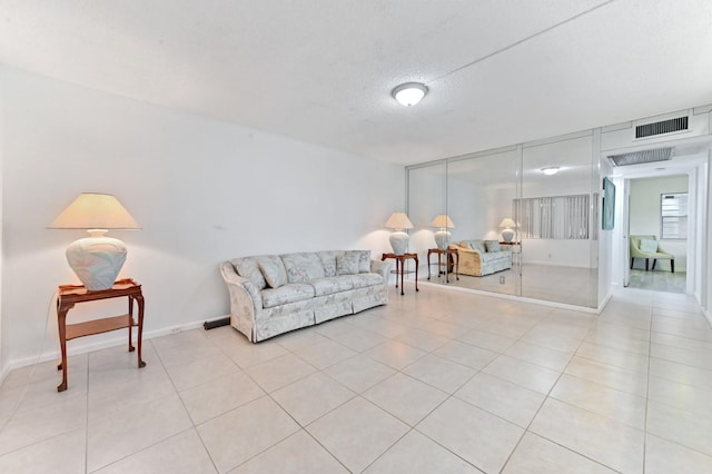 living room featuring a textured ceiling and light tile patterned flooring