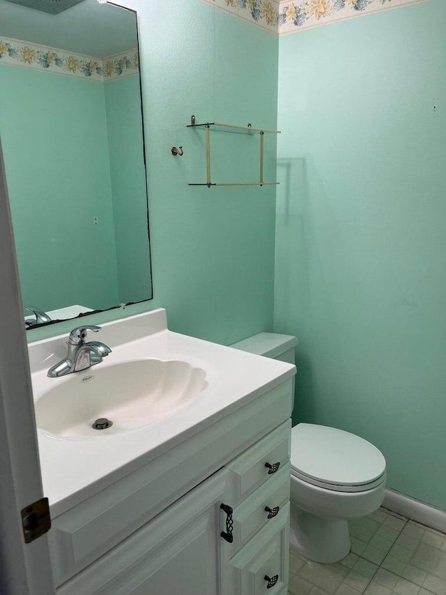 bathroom featuring tile patterned floors, vanity, and toilet