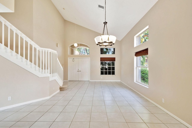 tiled entrance foyer with high vaulted ceiling and a notable chandelier