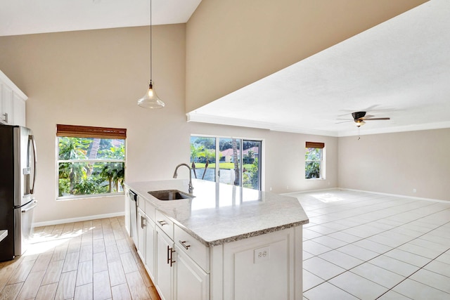 kitchen featuring white cabinetry, sink, ceiling fan, stainless steel appliances, and decorative light fixtures