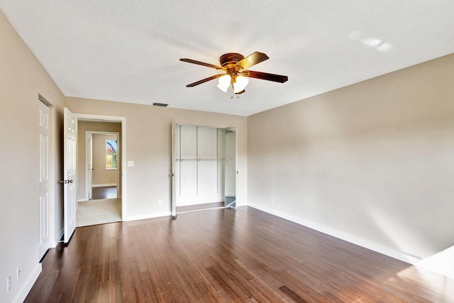 interior space with a textured ceiling, ceiling fan, and dark wood-type flooring