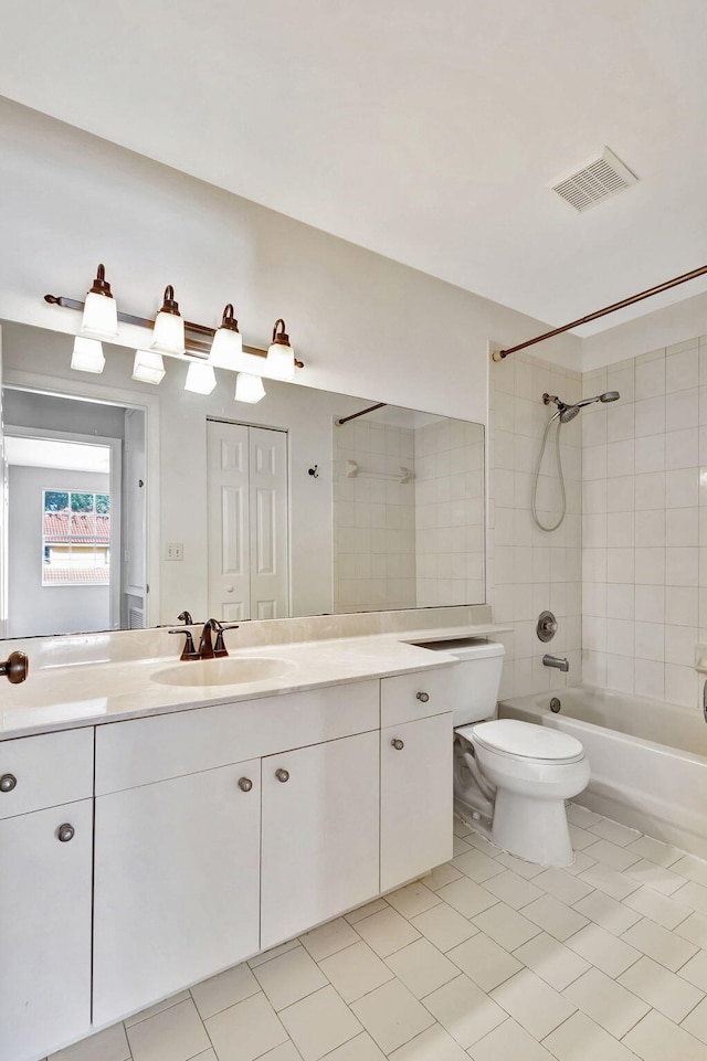 full bathroom featuring tile patterned flooring, vanity, tiled shower / bath combo, and toilet