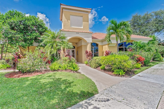 mediterranean / spanish-style home with a front lawn