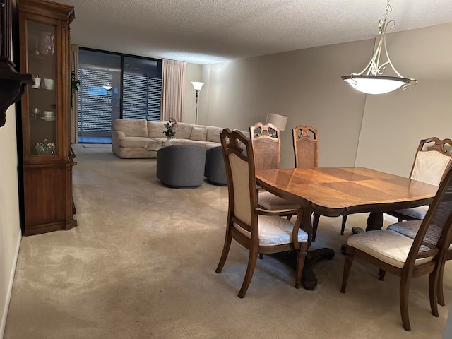 dining room featuring a textured ceiling and light carpet