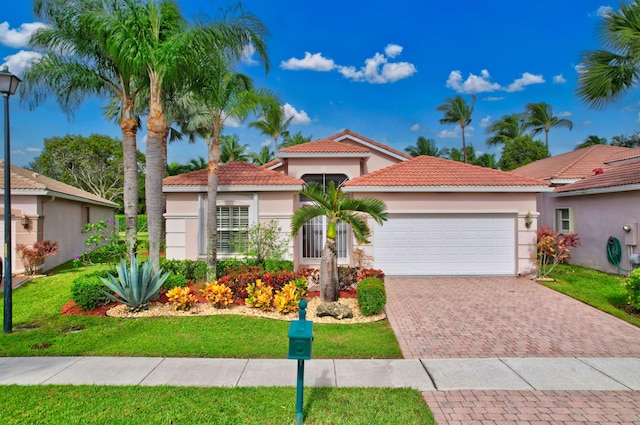 mediterranean / spanish home with a garage and a front lawn