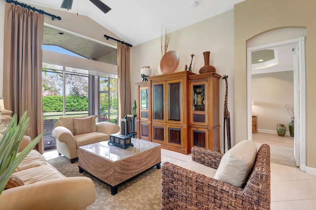 tiled living room with ceiling fan and lofted ceiling