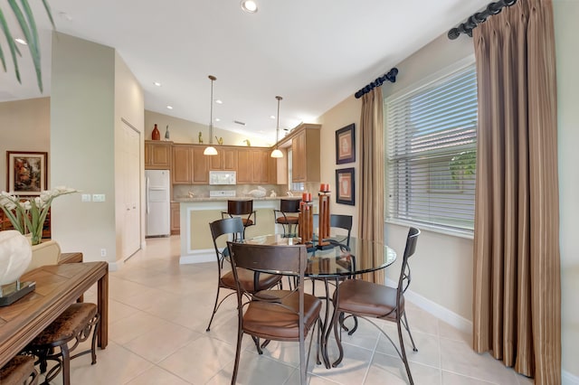 dining room with light tile patterned floors and vaulted ceiling