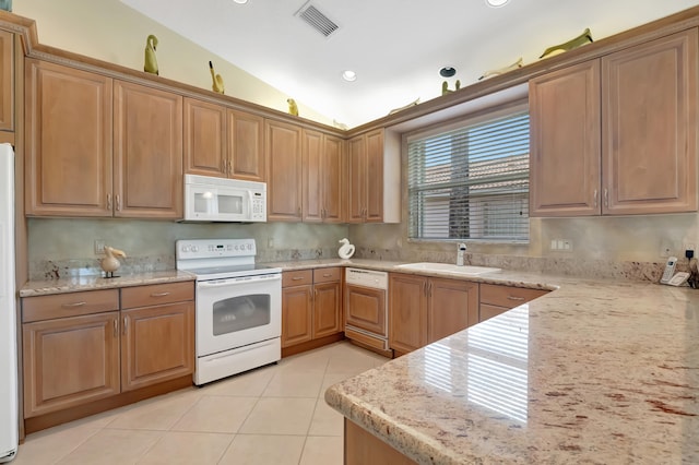 kitchen with sink, light stone counters, lofted ceiling, white appliances, and light tile patterned flooring