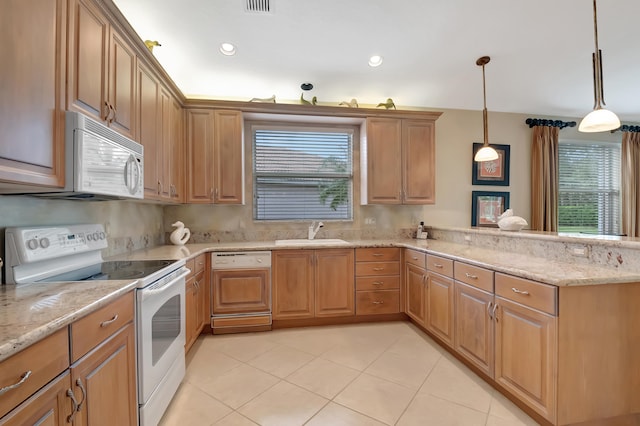 kitchen with plenty of natural light, sink, decorative light fixtures, and white appliances