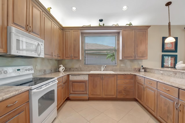 kitchen featuring pendant lighting, light stone countertops, white appliances, and sink