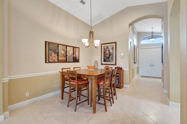 tiled dining area with an inviting chandelier and vaulted ceiling