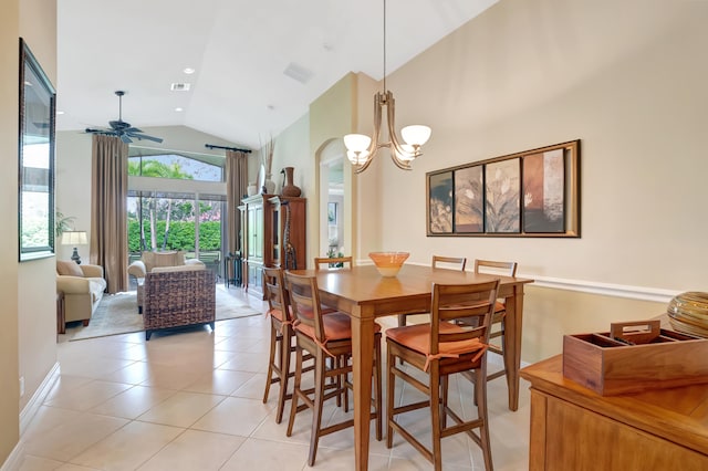 tiled dining area with ceiling fan with notable chandelier and high vaulted ceiling