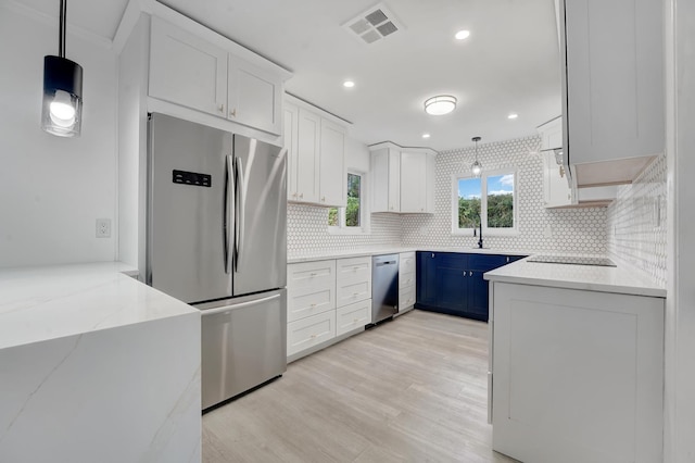 kitchen with white cabinets, pendant lighting, appliances with stainless steel finishes, and blue cabinets