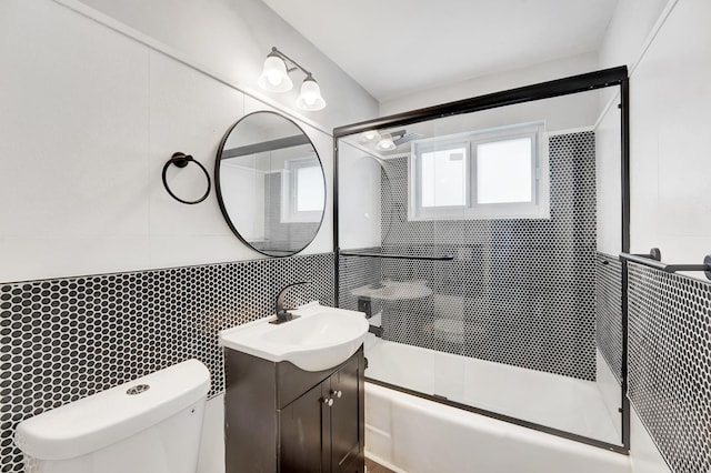 524 Lighthouse Dr, North Palm Beach, FL 33408 - full bathroom featuring tile walls, vanity, shower / bath combination with glass door, toilet, and tasteful backsplash