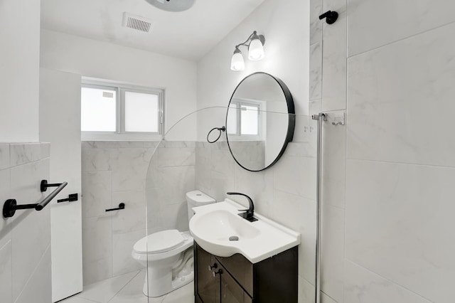 524 Lighthouse Dr, North Palm Beach, FL 33408 - bathroom with tile walls, plenty of natural light, toilet, and vanity