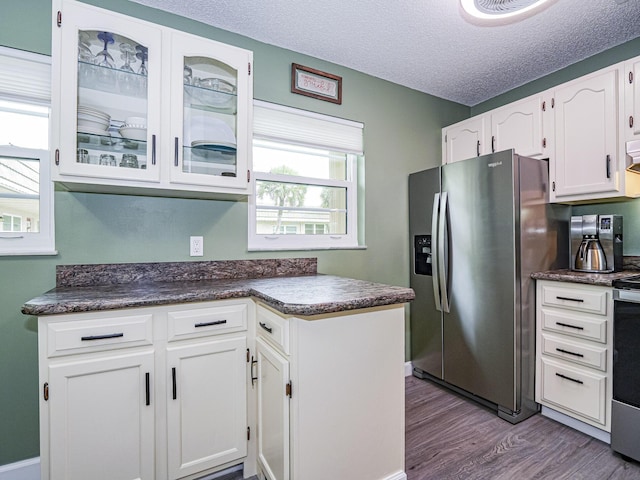 kitchen with white cabinetry, stainless steel fridge, light hardwood / wood-style floors, and a textured ceiling