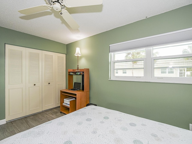 bedroom with dark hardwood / wood-style floors, ceiling fan, and a closet