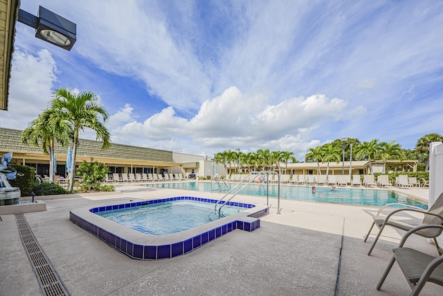 view of pool with a hot tub and a patio