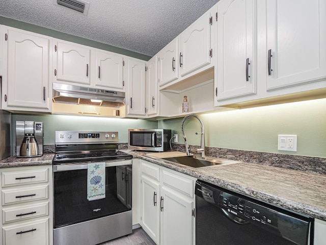 kitchen with white cabinetry, stainless steel appliances, sink, and a textured ceiling