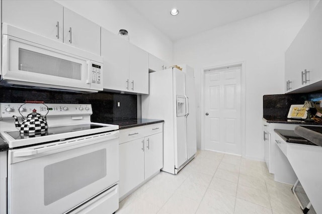 kitchen featuring white cabinets, decorative backsplash, and white appliances