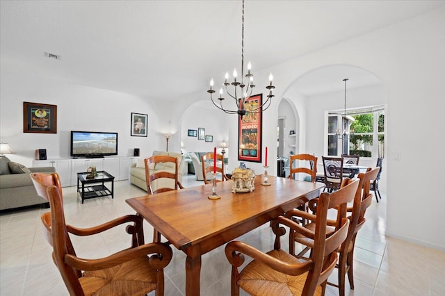 dining area with light tile patterned floors and a chandelier