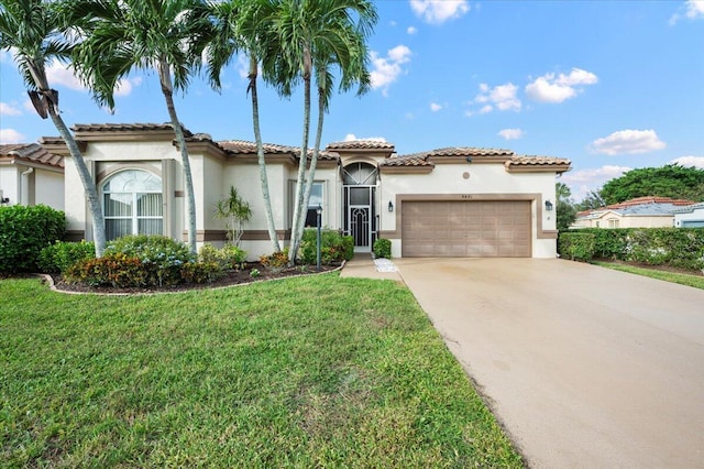 mediterranean / spanish house featuring a garage and a front yard