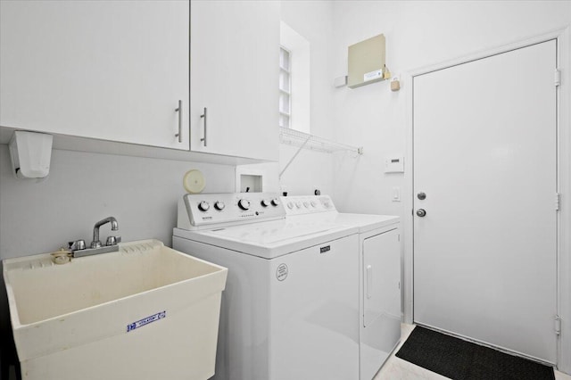 laundry room with cabinets, sink, and separate washer and dryer