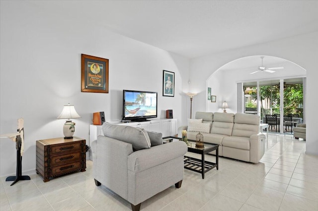 living room featuring ceiling fan, a wall of windows, and light tile patterned flooring