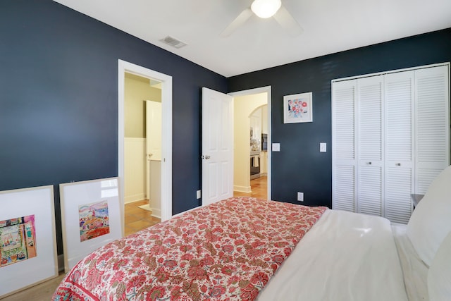 bedroom with light wood-type flooring, ceiling fan, and a closet