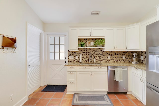 kitchen with decorative backsplash, white cabinetry, sink, and stainless steel appliances