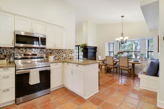 kitchen featuring white cabinetry, high vaulted ceiling, appliances with stainless steel finishes, and decorative backsplash