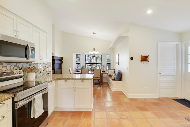 kitchen featuring stainless steel appliances, white cabinetry, decorative light fixtures, backsplash, and vaulted ceiling