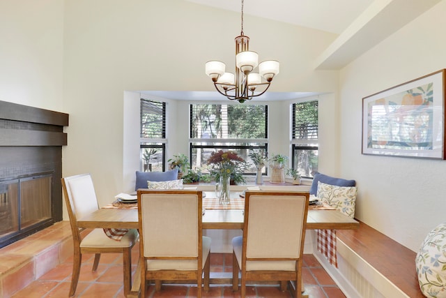 tiled dining space with a chandelier and vaulted ceiling