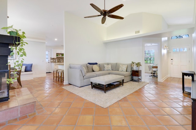 tiled living room with high vaulted ceiling and ceiling fan