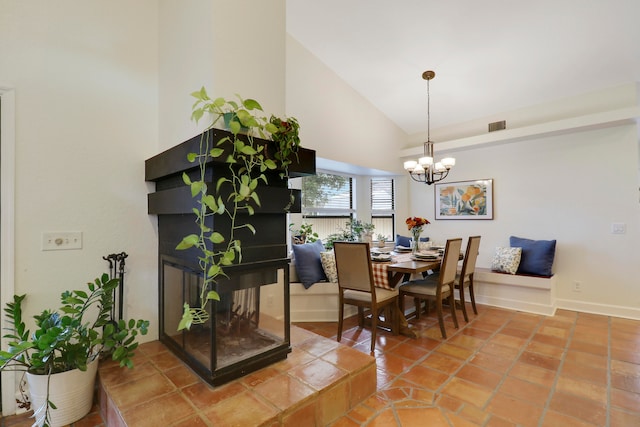 tiled dining room featuring high vaulted ceiling and a chandelier