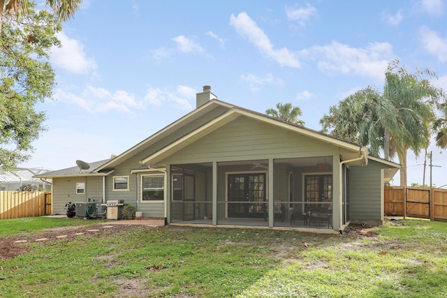 back of property with a lawn and a sunroom