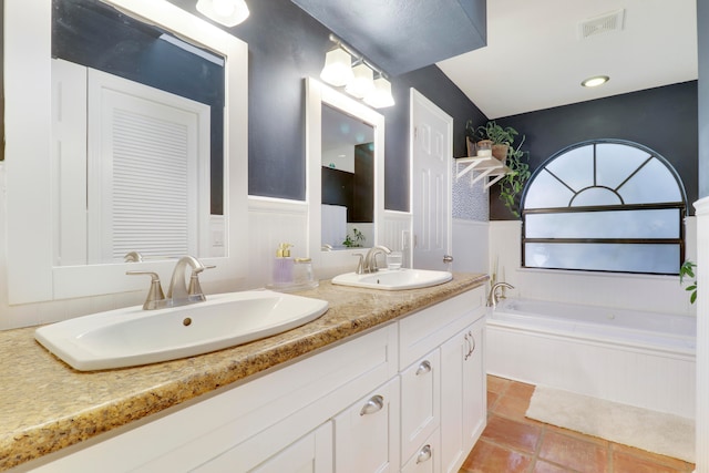 bathroom with vanity, tile patterned floors, and tiled tub