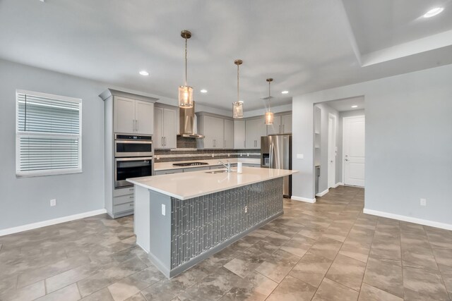 11461 SW Lyra Dr, Port Saint Lucie, FL 34987 - kitchen featuring stainless steel appliances, gray cabinetry, decorative backsplash, baseboards, and an island with sink
