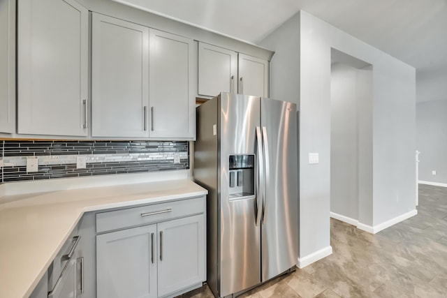 11461 SW Lyra Dr, Port Saint Lucie, FL 34987 - kitchen featuring stainless steel fridge with ice dispenser, gray cabinetry, decorative backsplash, and light countertops
