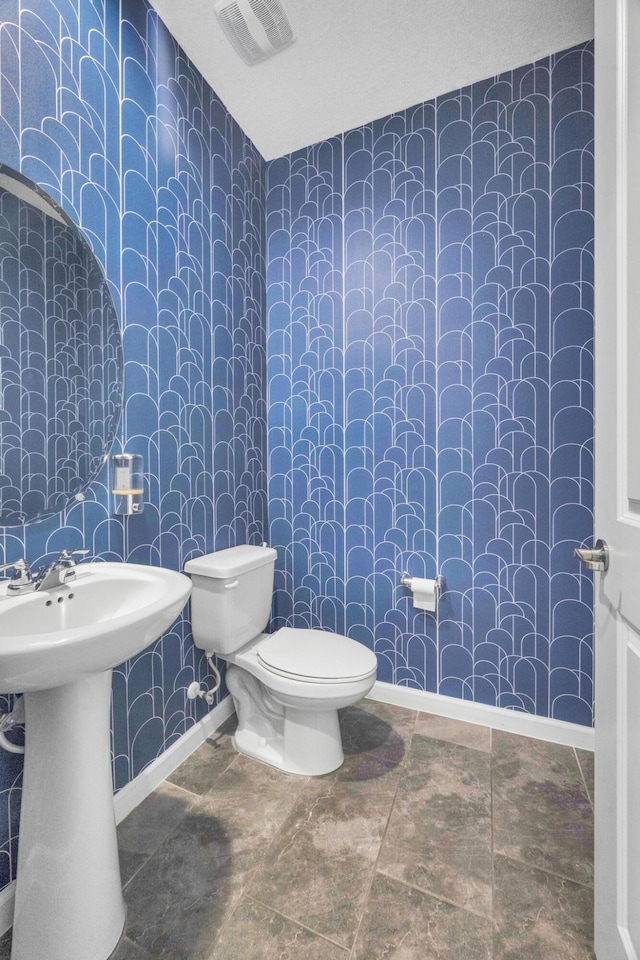 11461 SW Lyra Dr, Port Saint Lucie, FL 34987 - bathroom with wallpapered walls, toilet, baseboards, and a sink